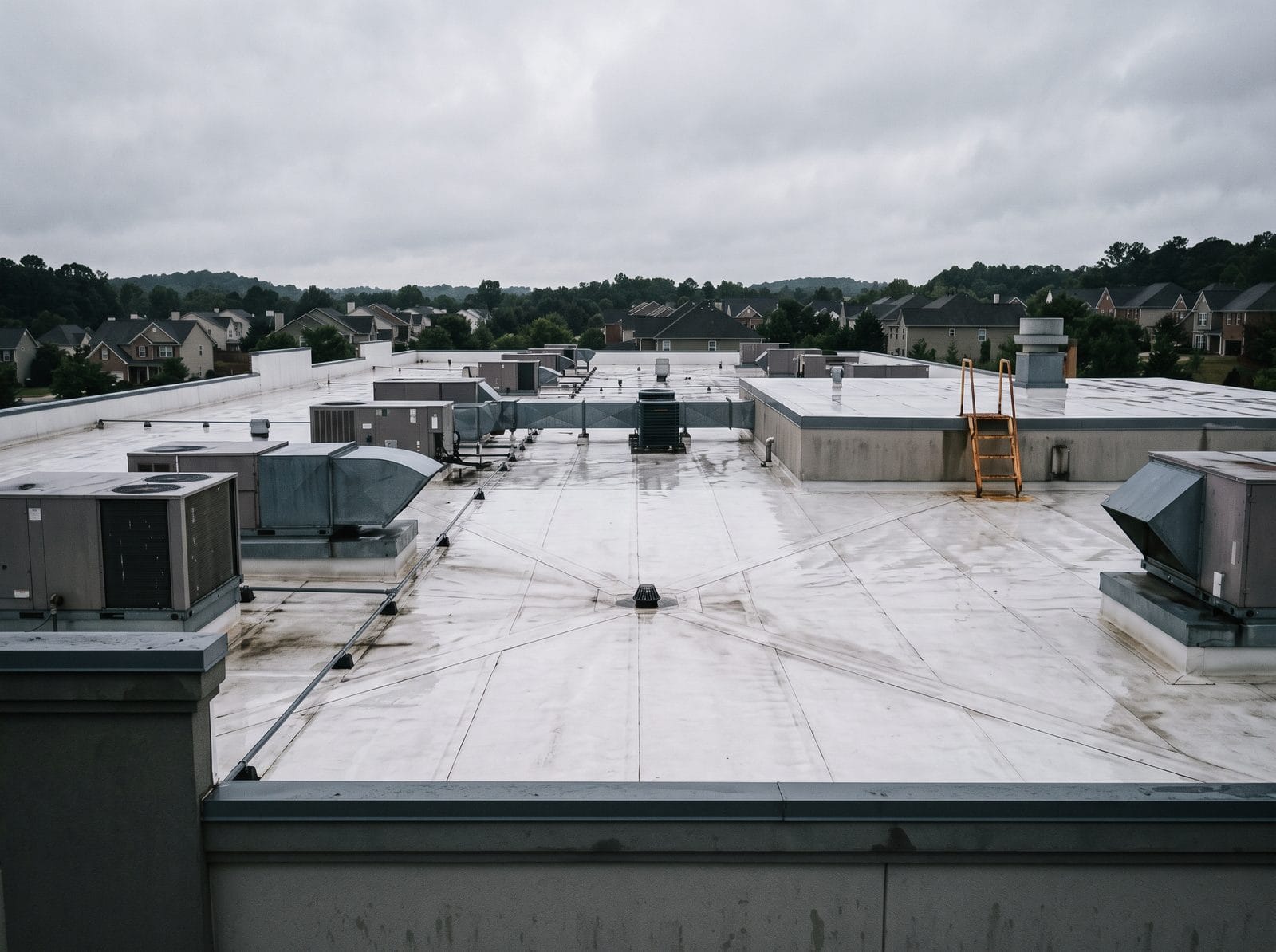 A large single-ply membrane roof with mechanical units, seen from the parapet.